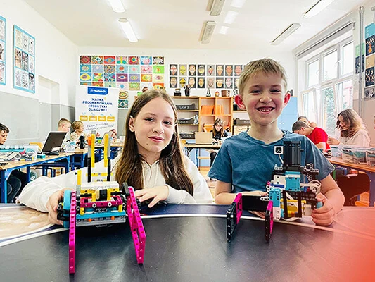 Dzieci prezentują zbudowane roboty LEGO.